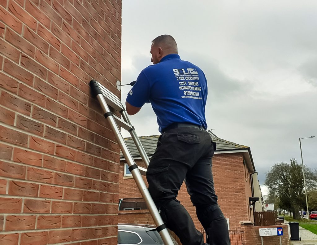 Professional CCTV installer from S.L. Locksmith fitting a security camera on a residential property. Expert security solutions for homes and businesses